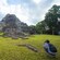 Tourists take pictures of a Mayan temple